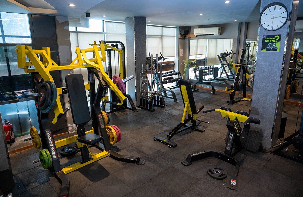 Modern sports facility with athletes training on indoor basketball court and weightlifting area